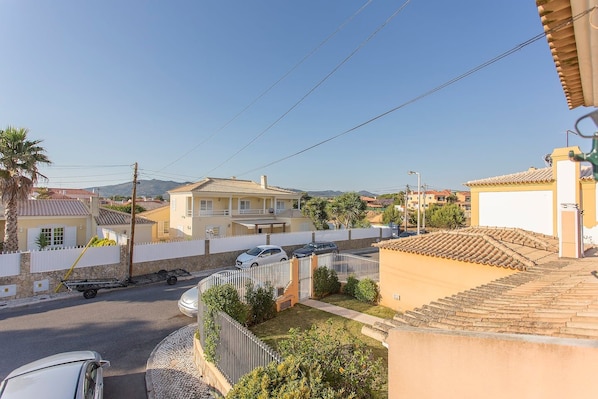 Zona residencial con casas, una calle pavimentada y cielo despejado.