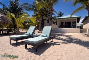 Relax in comfort on the beach with two lounge chairs and a tranquil view.