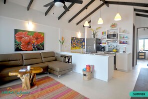 Relax in this stylish living space with a central kitchen island, comfortable sofa, and vibrant rug.