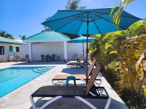 Relax by the serene pool surrounded by lush tropical plants and lounge under the shade of umbrellas.