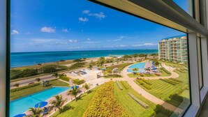 Un complexe hôtelier doté de plusieurs piscines, d’un grand bâtiment et offrant une vue sur l’océan.