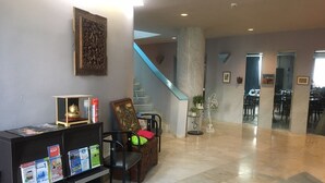Un hall d’entrée avec un comptoir de réception, un escalier et un espace repas.