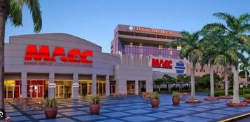 El centro de convenciones del Aeropuerto de Miami y el hotel DoubleTree, con una plaza a cuadros y palmeras.