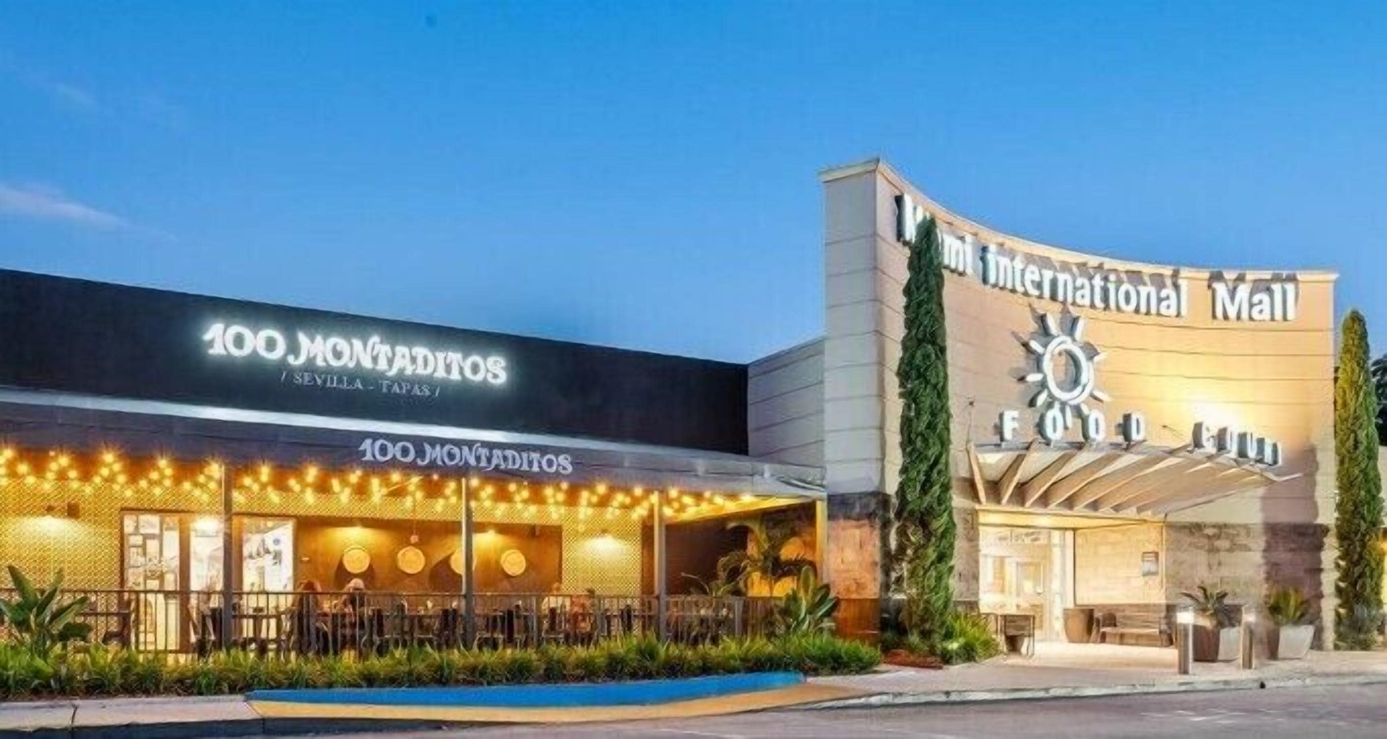 Ein Gebäude mit Schildern für '100 Montaditos Sevilla Tapas' und 'International Mall Food Court'.