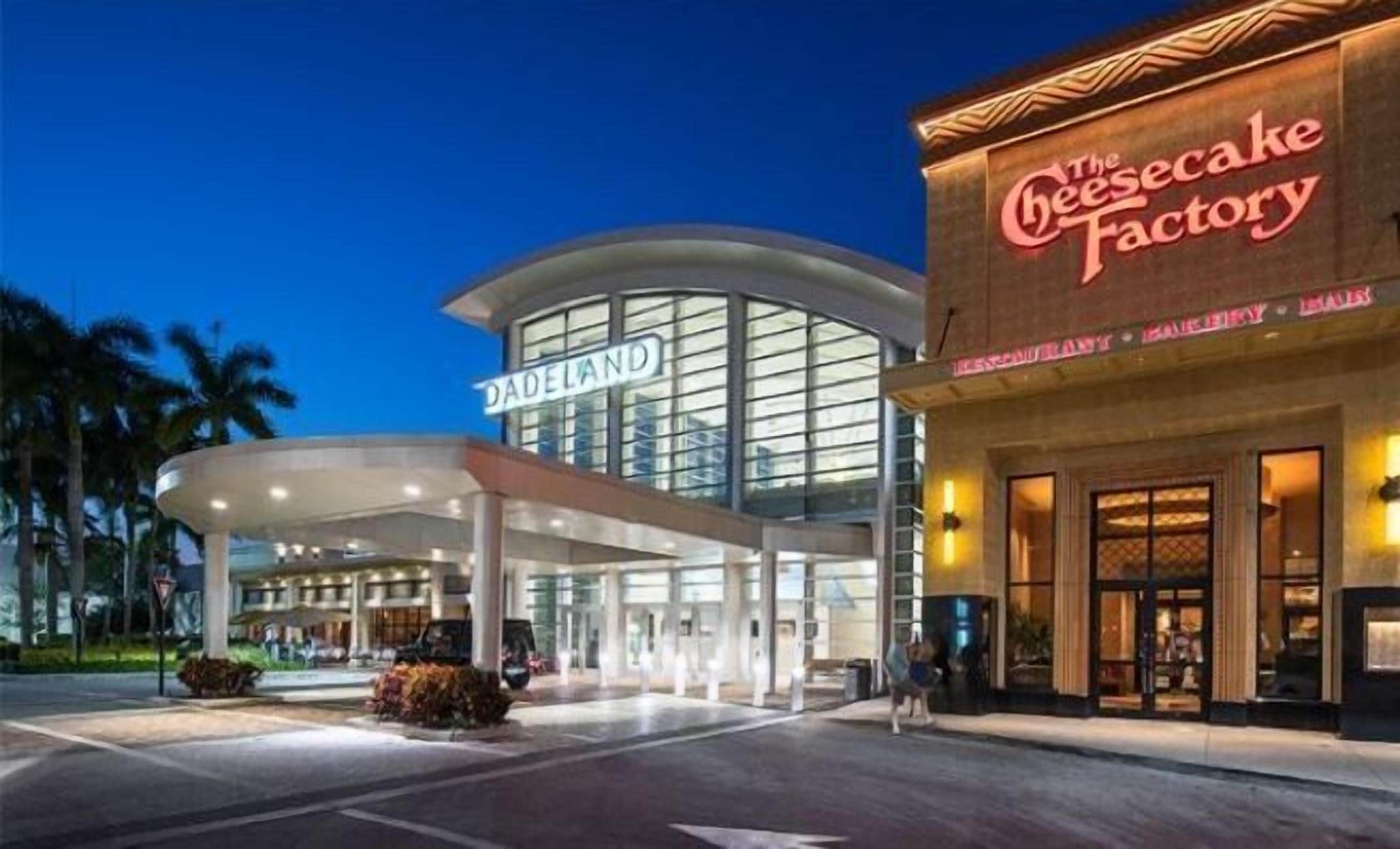 A hotel with a modern design, featuring a prominent sign for 'The Cheesecake Factory' restaurant.