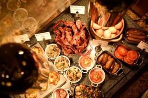 A buffet with various dishes including meats, vegetables, and eggs.