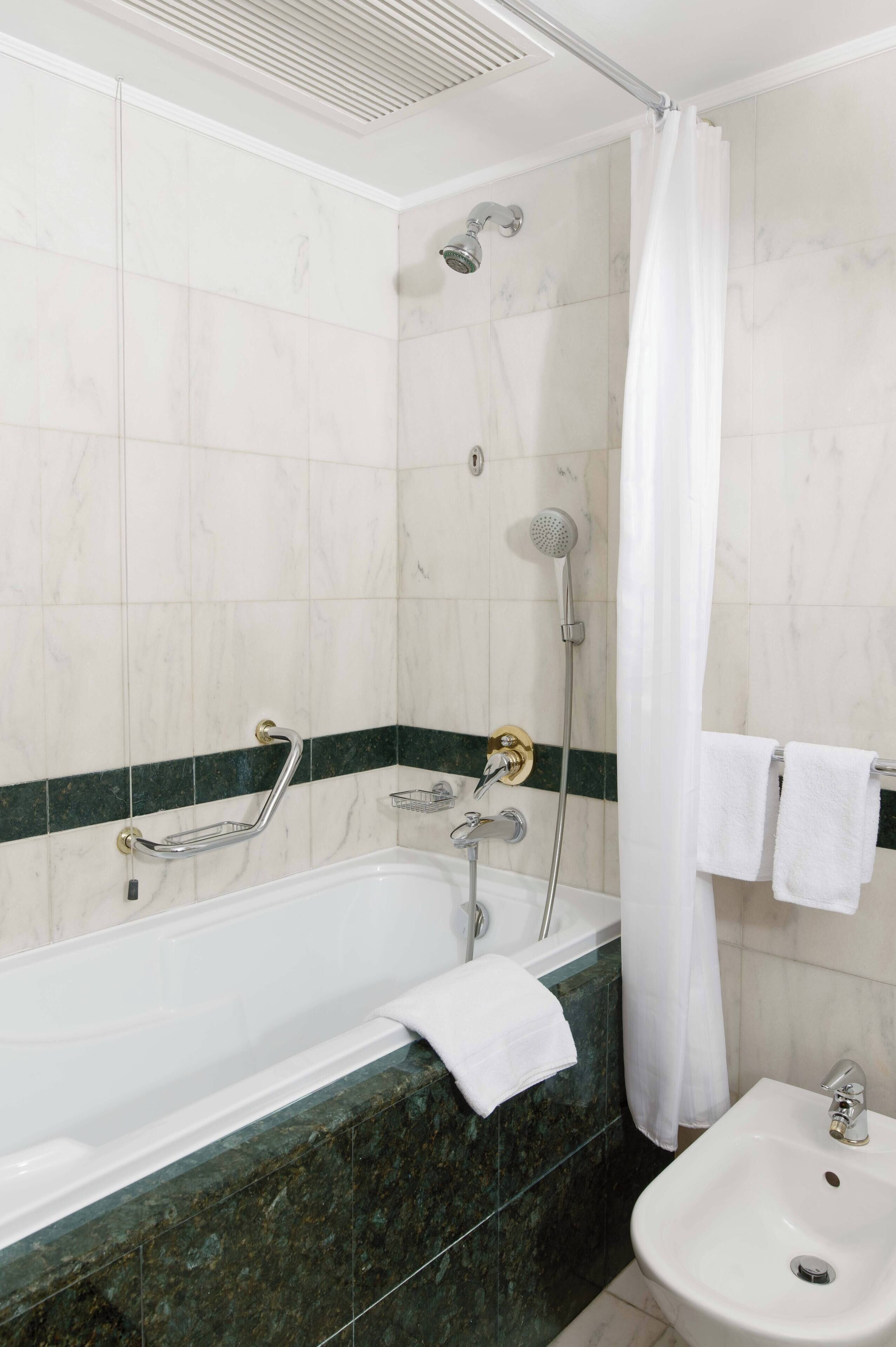 Un baño con bañera, ducha y lavamanos.