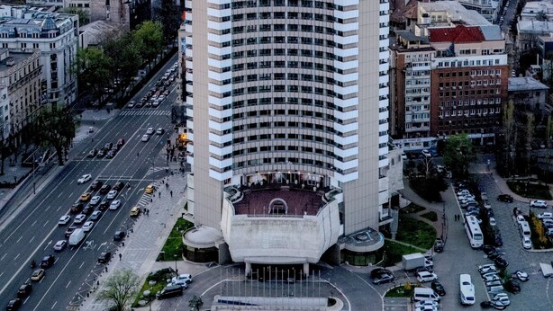 A high-rise hotel with a prominent entrance, surrounded by a cityscape and a busy street. - Grand Hotel Bucharest (Bucharest)