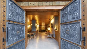 Un interno in legno con pavimento in pietra, una zona pranzo con sedie e un tavolo.