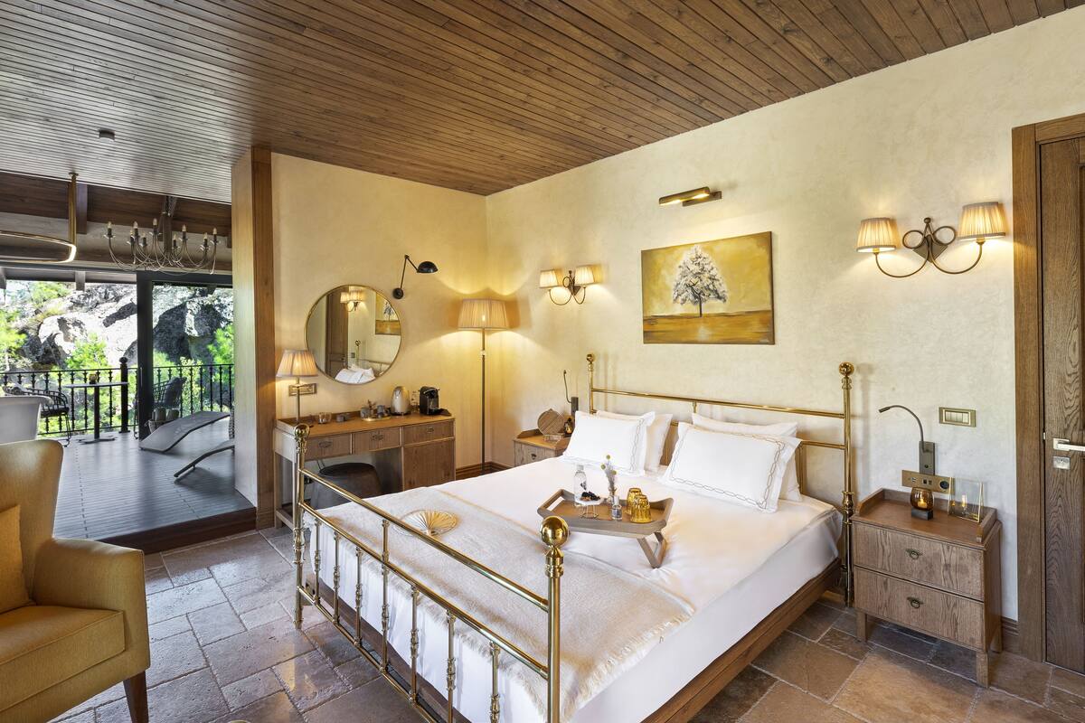 Un dormitorio con cama, mesitas de noche, cómoda y ventana con vistas a un balcón.