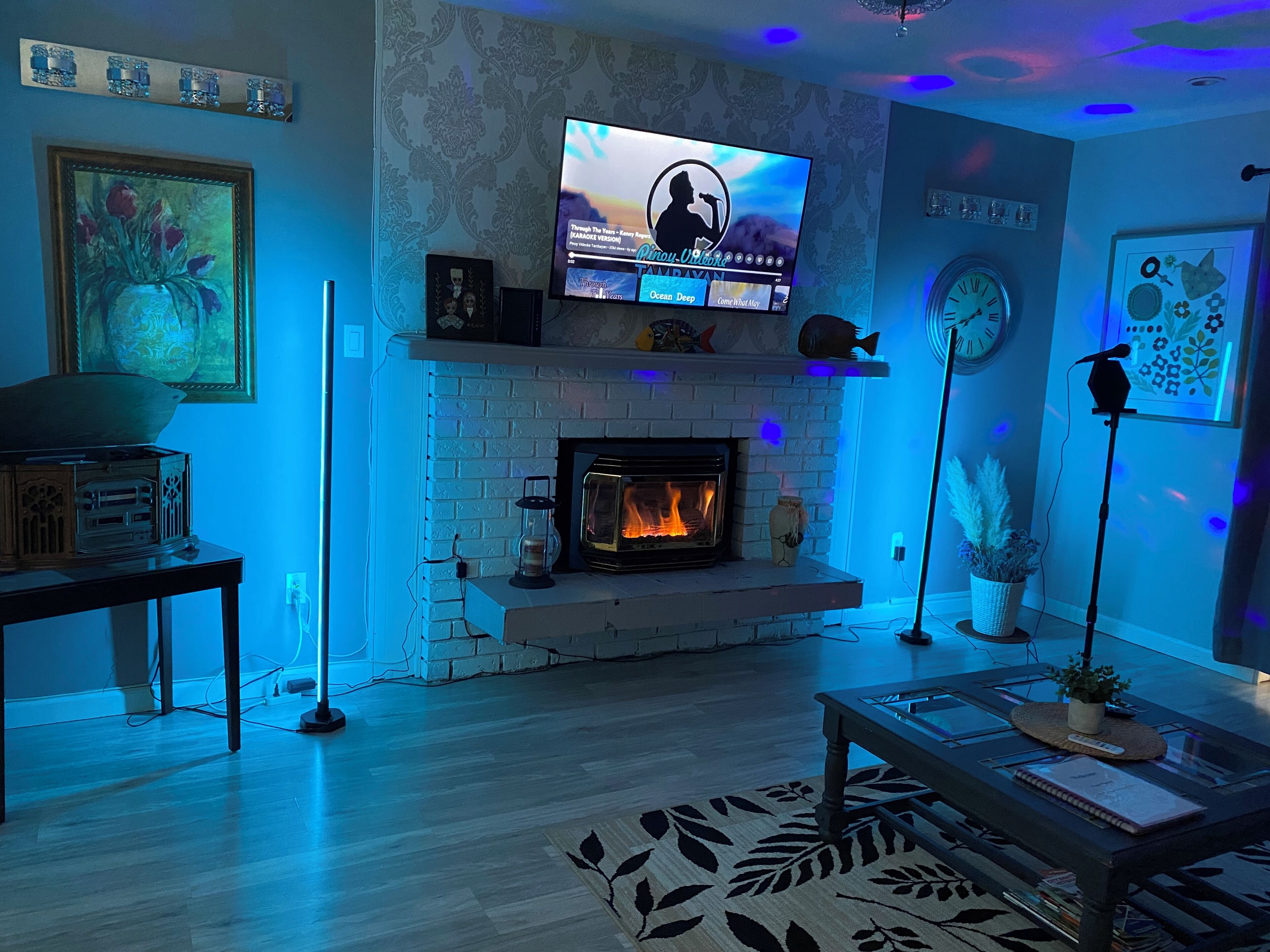A living room with a fireplace, a television mounted above it, and a modern decor style.