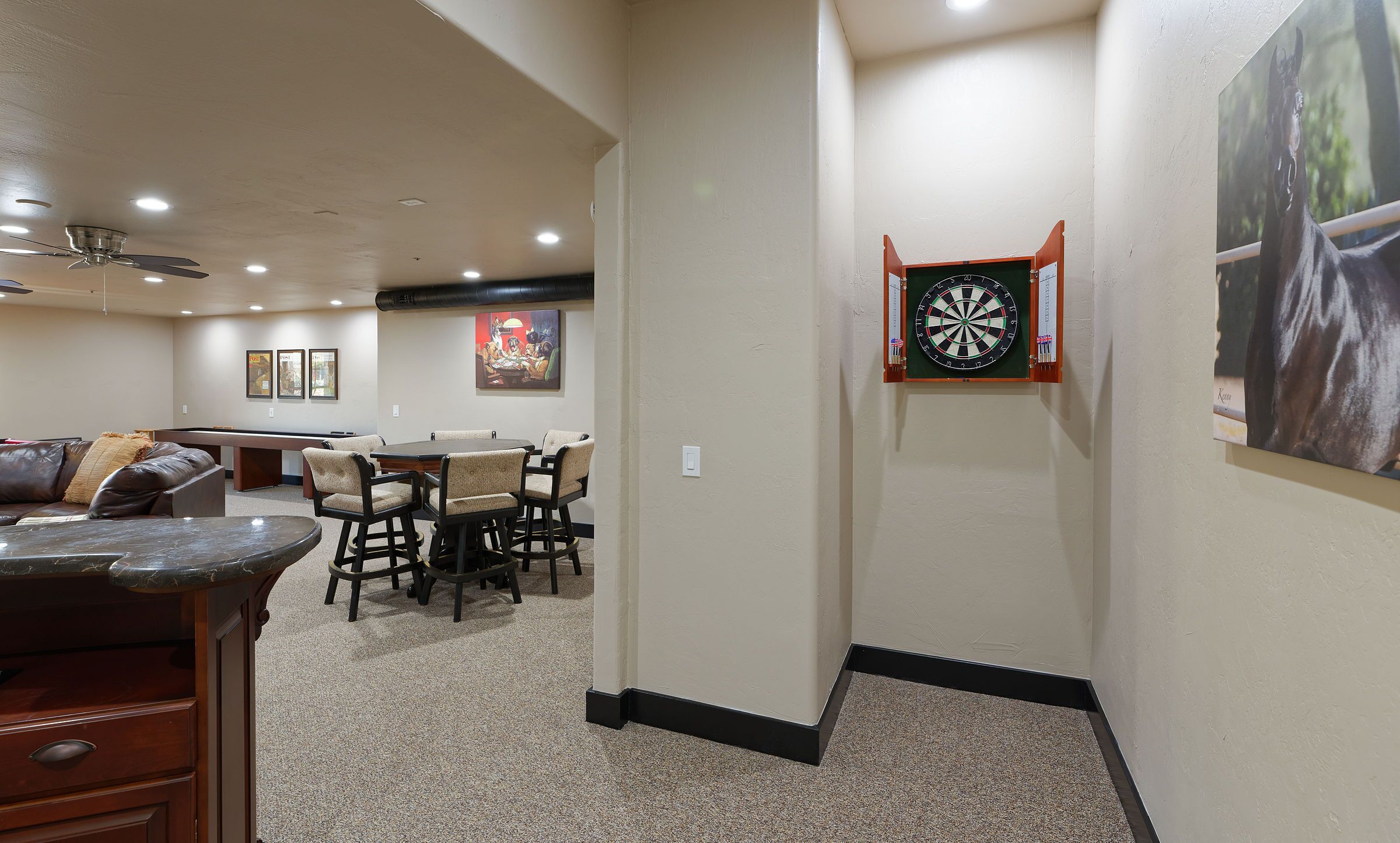 A room with a dartboard, a pool table, and a billiards table.