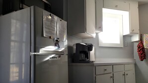 A kitchen with a refrigerator, a coffee maker, and cabinets. - Relaxing 2 bedroom river side home. Home located in Banner Elk, NC  (Banner Elk)