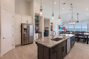 A modern kitchen with a central island, stainless steel appliances, and pendant lighting.