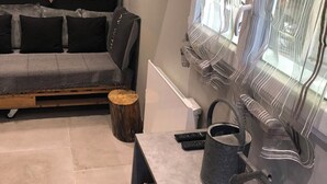 Un salon moderne avec un canapé, une table basse, une cheminée et une fenêtre avec des rideaux.