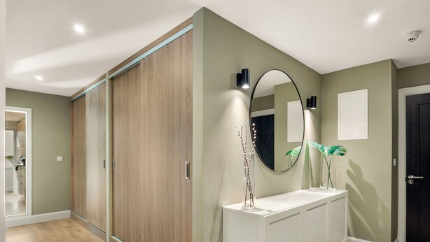 A modern bathroom with a wooden wardrobe, a white vanity, a round mirror, and a small plant. - Apartment 293 - Clifden - sleeps 4 guests  in 2 bedrooms (Clifden)