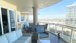 Ein Balkon mit einer Couch, Stühlen und einem Tisch.
