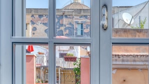 A modern room with a large window, a laptop on a desk, and a chair. - IzzHome Corso76 (Cagliari)