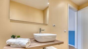 A bathroom with a white sink, a mirror, and a towel on the counter.