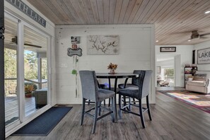 Een eetgedeelte met een tafel en stoelen, een kaart aan de muur en uitzicht op het omliggende landschap.
