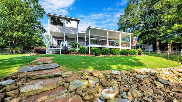 A two-story house with a covered porch and a stone pathway leading to the front door. - Allie’s on the Rocks Pet-Friendly Lakefront Bungalow (Cullman)
