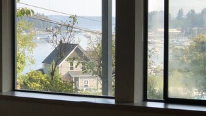 Vista a través de una ventana que muestra una casa, un puente y una masa de agua.
