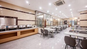 A spacious dining area with multiple tables and chairs, a buffet counter with food dispensers, and a modern interior design. - Paibai Yun Hotel (Dalian Xianglujiao Light Rail Station Branch) (Dalian)