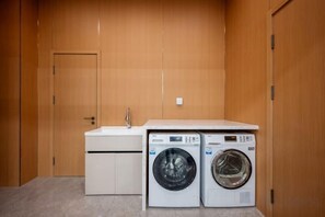 A laundry area with two washing machines and a sink. - Paibai Yun Hotel (Dalian Xianglujiao Light Rail Station Branch) (Dalian)