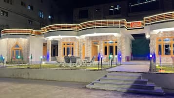 Vista frontal de la propiedad por la tarde o noche