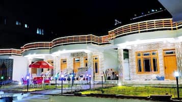 Vista frontal de la propiedad por la tarde o noche