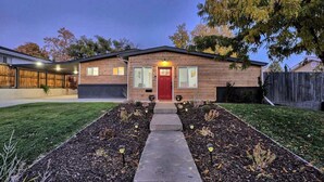 A single-story house with a red door, a front porch, and a well-maintained lawn. - Outdoor Oasis: Unwind in the hot tub under twinkling lights in your private retreat! (Arvada)