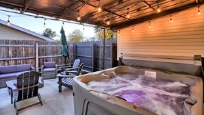 A hot tub with a wooden deck, outdoor seating, and string lights. - Outdoor Oasis: Unwind in the hot tub under twinkling lights in your private retreat! (Arvada)