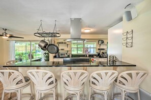 Enjoy cooking in this well-equipped kitchen with a central island, stainless steel appliances, and a large window.