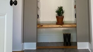 A hallway with a white door, a potted plant, and a bench. - The Thistle House off Chardon Square (Chardon)