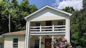 A two-story house with a porch, a front door, and a mailbox. - The Thistle House off Chardon Square (Chardon)