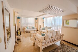 A spacious living room with a white sofa set, a coffee table, and a patterned rug. - Kilua Residences by Cityblue (Mombasa)