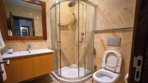 A modern bathroom with a glass-enclosed shower, a sink, and a toilet. - Kilua Residences by Cityblue (Mombasa)