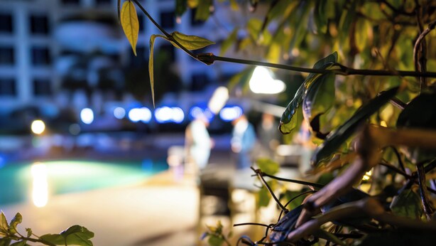 A nighttime view of a pool area with blurred lights in the background. - Kilua Residences by Cityblue (Mombasa)