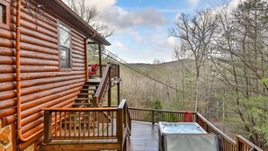 A log cabin with a wooden deck, a hot tub, and a view of the surrounding forest. - 4.3 miles to BR center, Private, Family Fun, Hot Tub, Serene  (Blue Ridge)