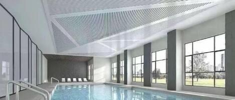 Una piscina con diseño de techo moderno, ventanas amplias y vistas despejadas al exterior.