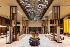 Eine geräumige Lobby mit einer zentralen Zierbrunnen, hohen Decken und modernen Beleuchtungselementen.