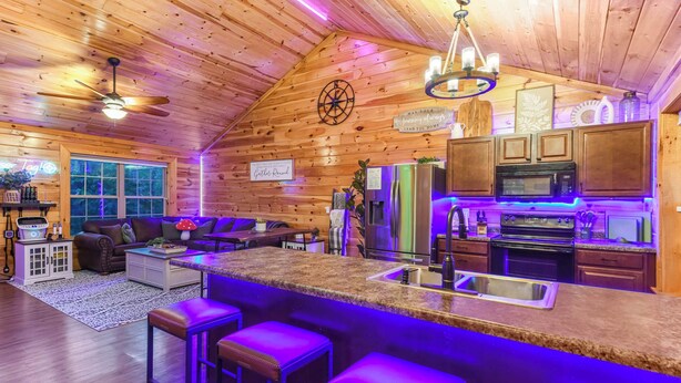L’intérieur d’une cabane en rondins comprend une cuisine, un coin bar et un salon.