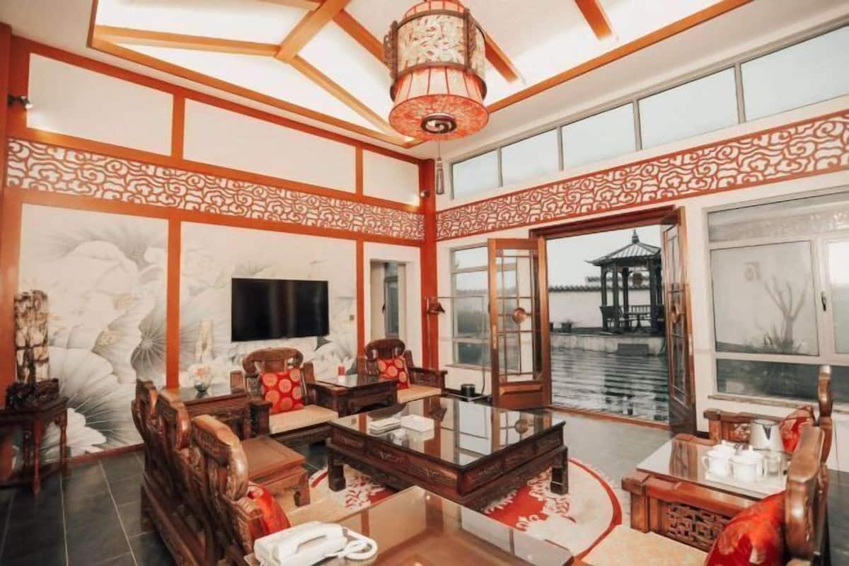 Habitación tradicional con techo de madera, un ventanal y vista a un cuerpo de agua.