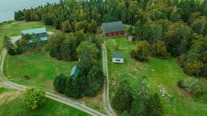 An aerial view of a rural property with multiple buildings, a golf course, and a lake.