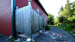 A red building with a wooden deck and a metal railing.