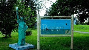 A statue of the Statue of Liberty and a sign that reads "Passport USA".