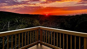 Panorama al tramonto da un pontile di legno con ringhiera.