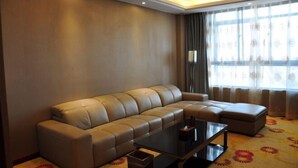 Una sala de estar moderna con un sofá, una mesa de centro y un ventanal con cortinas.