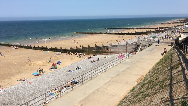 Une plage dotée d’une promenade, de zones de sable et d’une partie rocheuse.