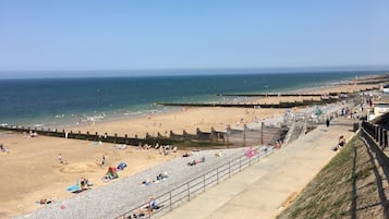 A beach with a promenade, sandy areas, and a rocky beach section.